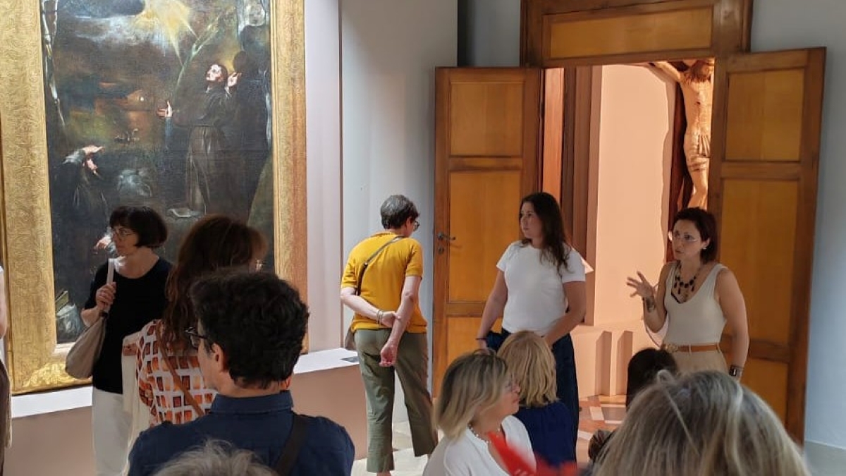 Persone che assistono durante una visita guidata alla mostra in pinacoteca diocesana a Senigallia "Sulla via di Francesco" alle spiegazioni della curatrice e storica Lorenza Zampa